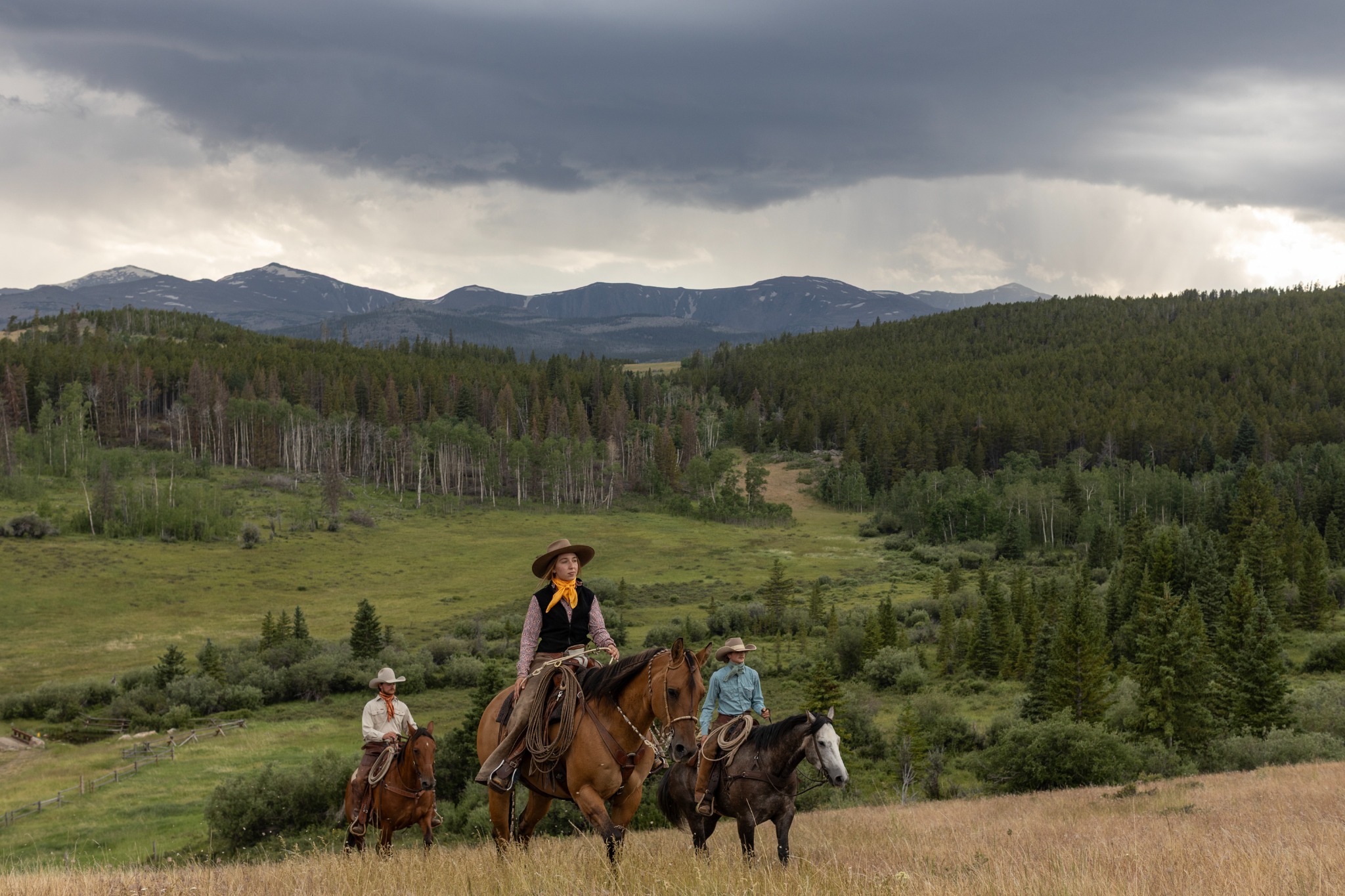 Horsewomen riding through mountain country